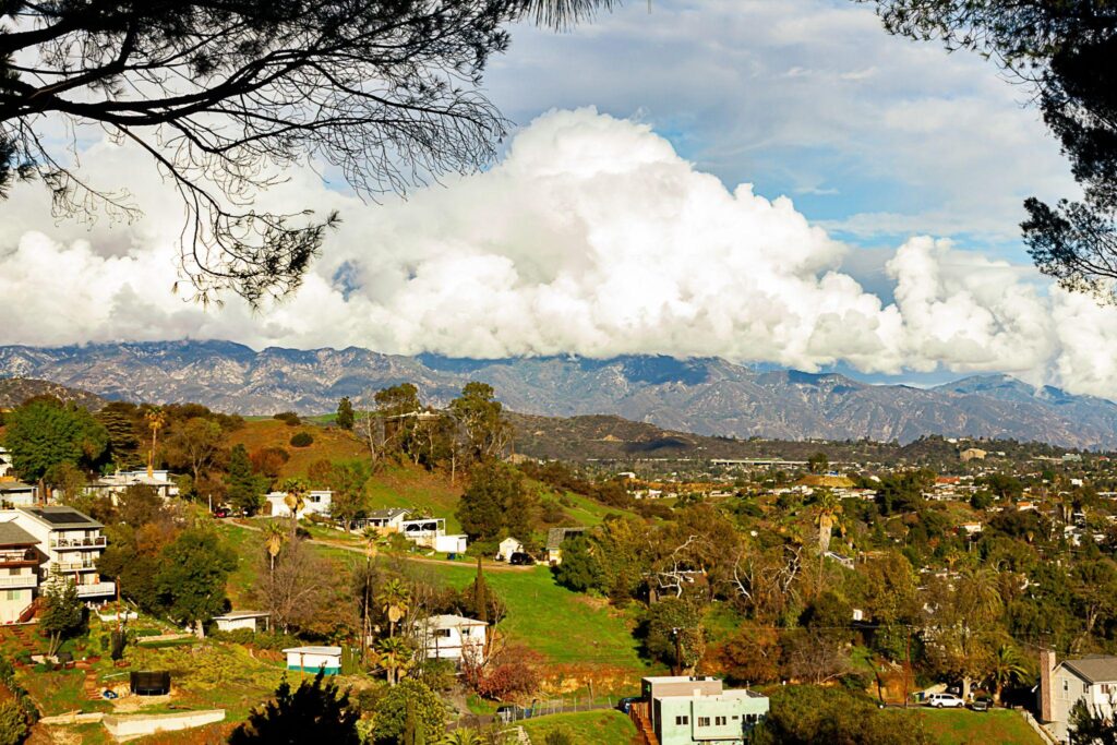 Hillside homes mountain range with huge cumulus nimbus clouds