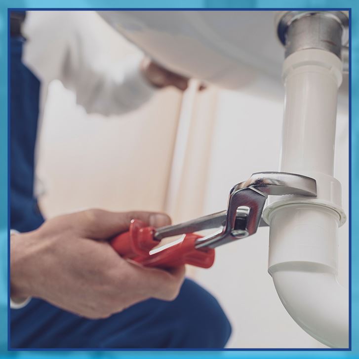 plumber tightening nut under new sink fixture