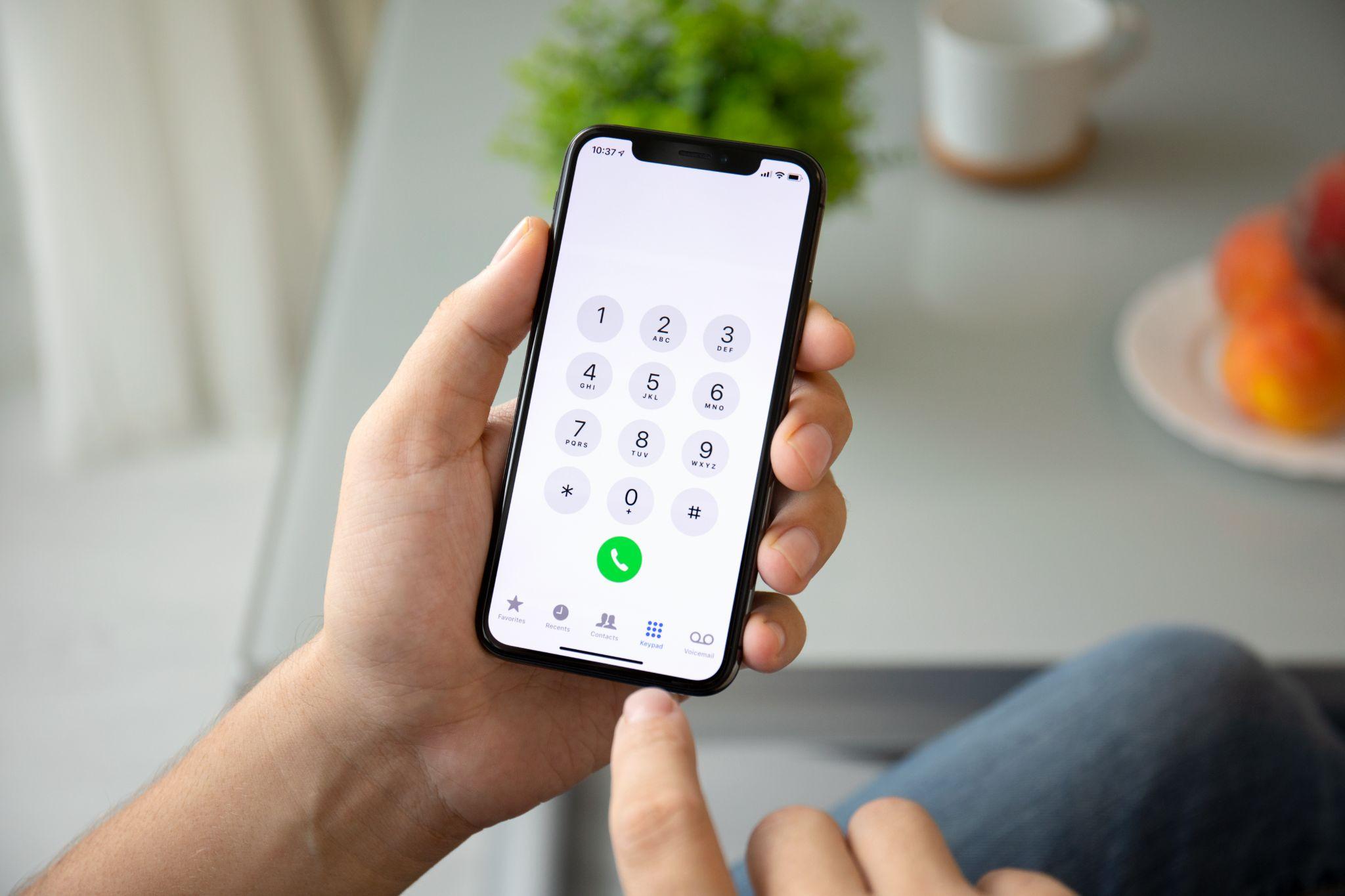 Man hand holding Phone with call number on screen