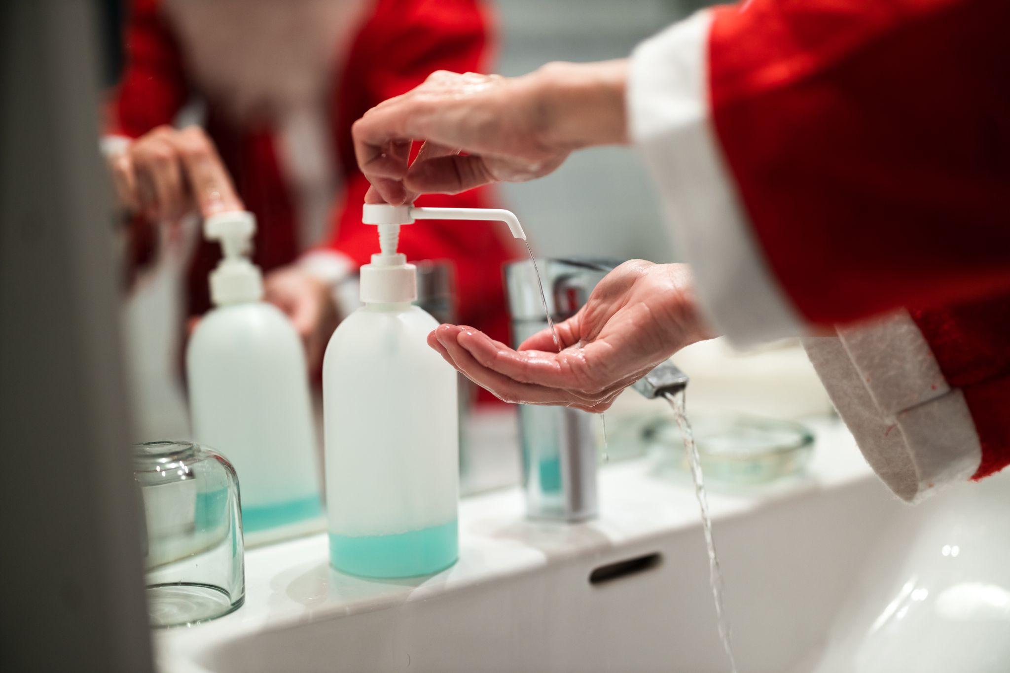 A mean dressed as Santa washing his hands