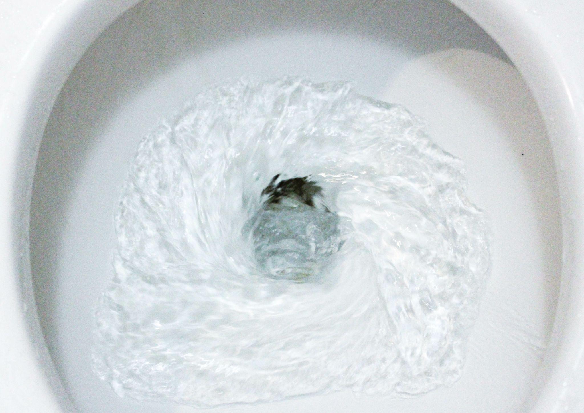 Close up of the water in a toilet flushing
