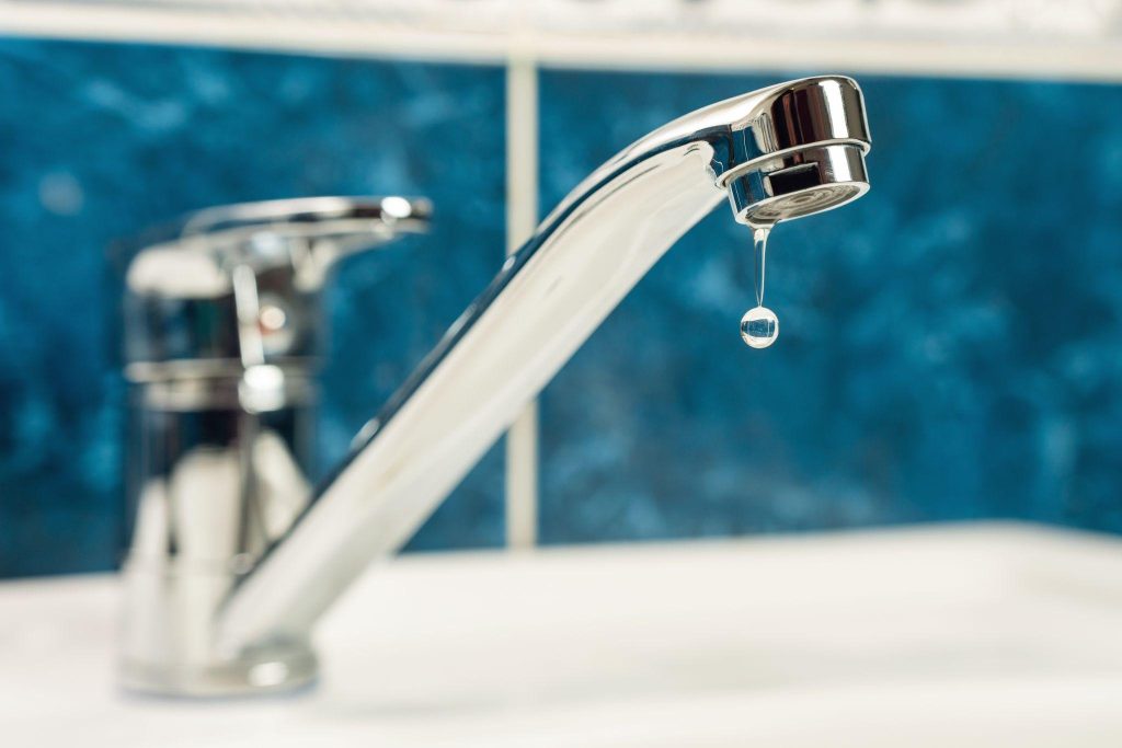 A Drop Of Water Drips From A Leaky Faucet