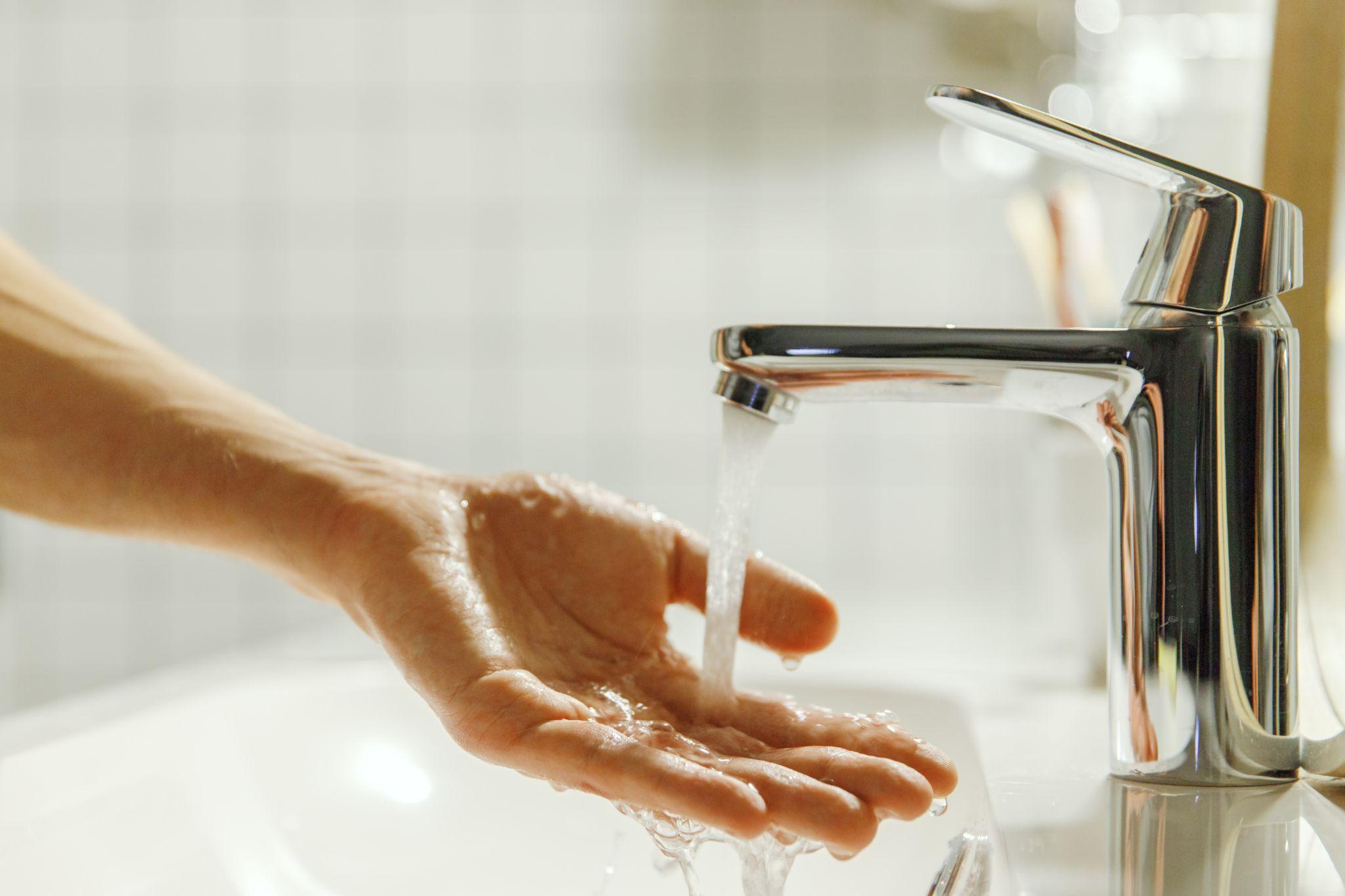 Man washing and cleaning her hand in bathroom