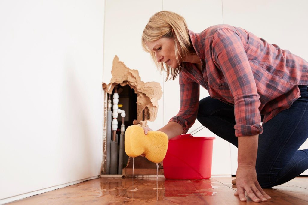Plumbing damage caused by a California wildfire. A burst pipe leaking from a wall.