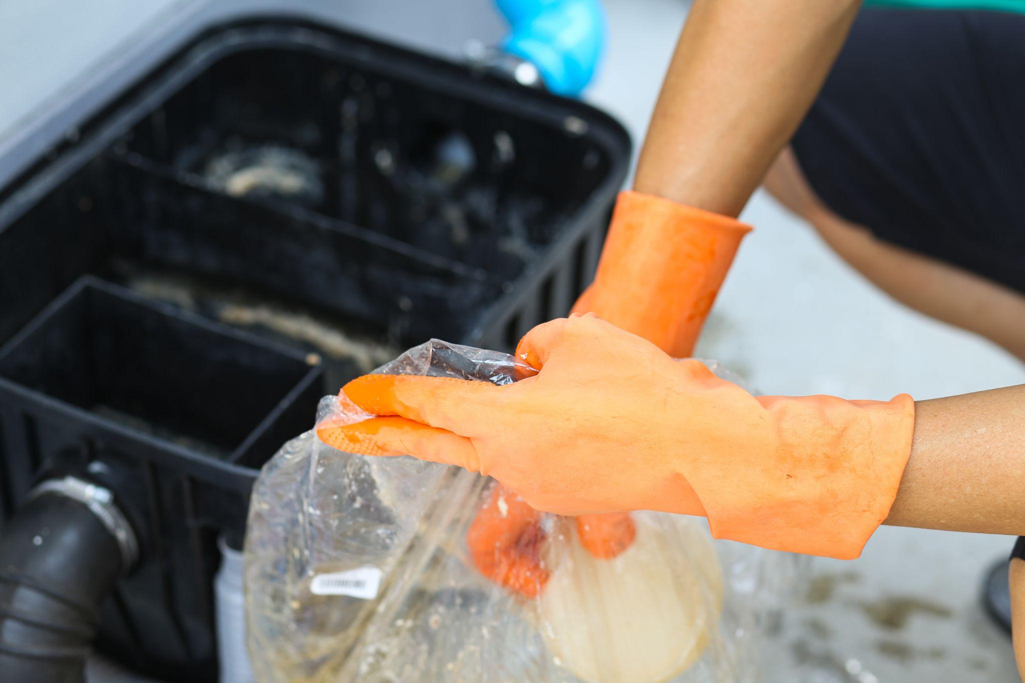 Man cleaning commercial grease trap