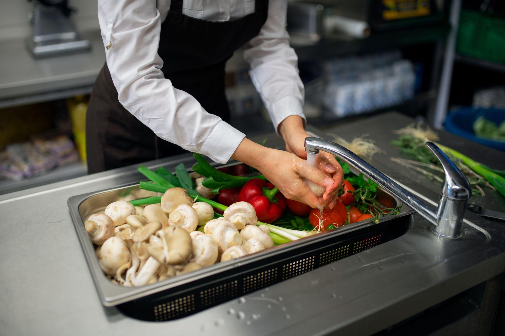 Commercial sink being used to wash vegetables