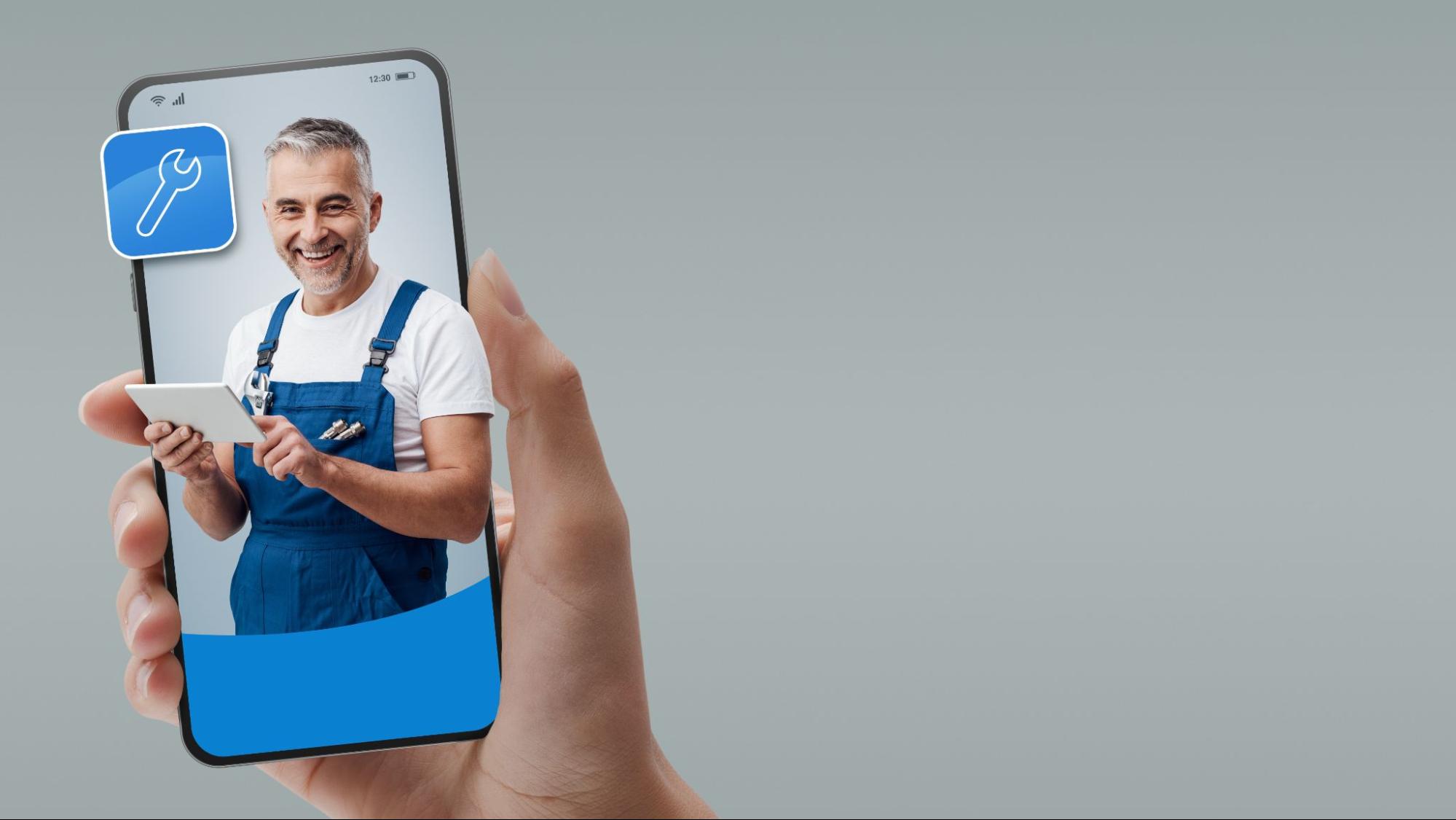 A graphic representation of a plumber on a phone being held by a hand