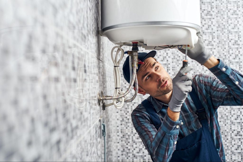 A plumber repairing a water heater