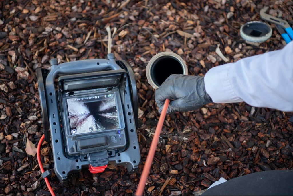 A plumber using a camera to look into a sewer