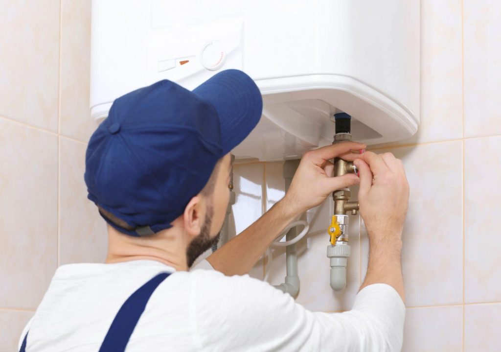 A plumber fixing an electric water heater