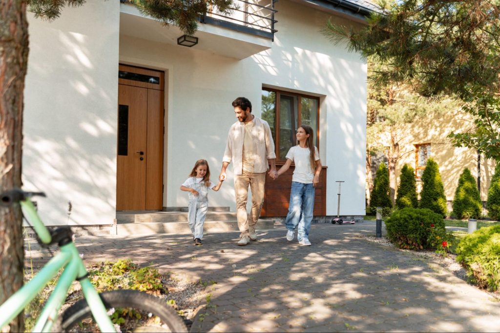 A man and his daughters leaving their home