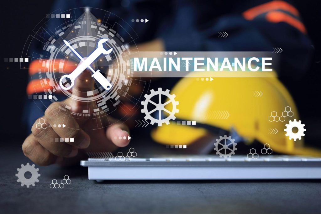 Maintenance engineer working on desktop with laptop computer and wrench symbol.